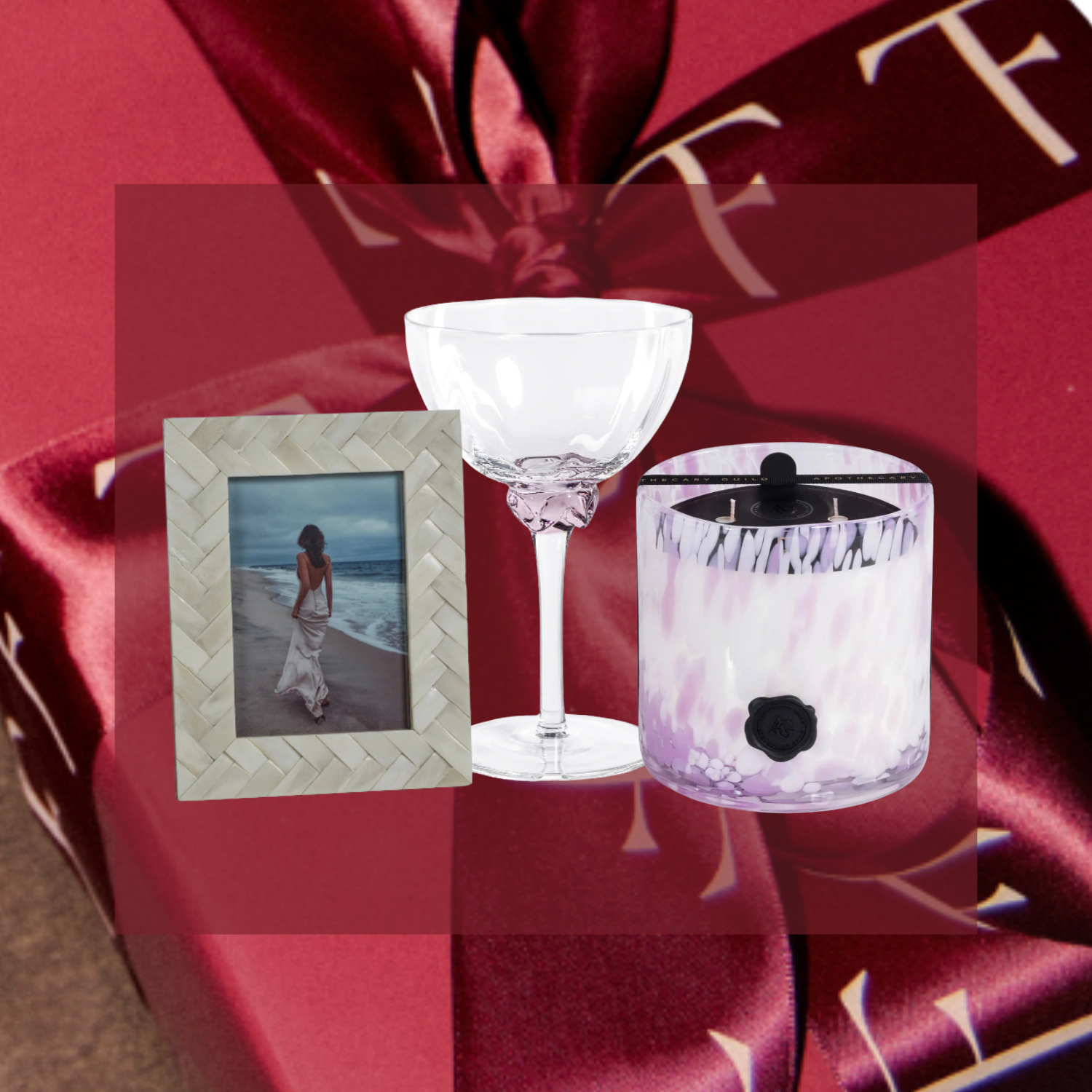 Decorative setup with a glass, photo frame, and candle on a red fabric background.
